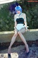 A woman in a bunny costume sitting on a stone wall.