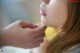 A close up of a woman's face with her hand on her chin.