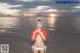 A woman in a bikini standing on a beach.