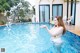 A woman in a bikini standing in a swimming pool.