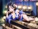 A woman in a blue kimono laying on a wooden bench.