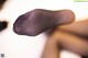 A close up of a woman's foot in black pantyhose.