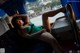 A woman in a green dress laying on a bus.